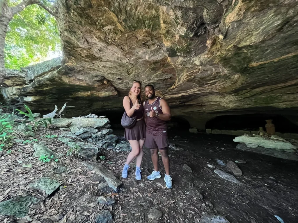 Happy couple giving thumbs up while exploring a hidden Mayan cave during a private adventure tour in Cozumel.