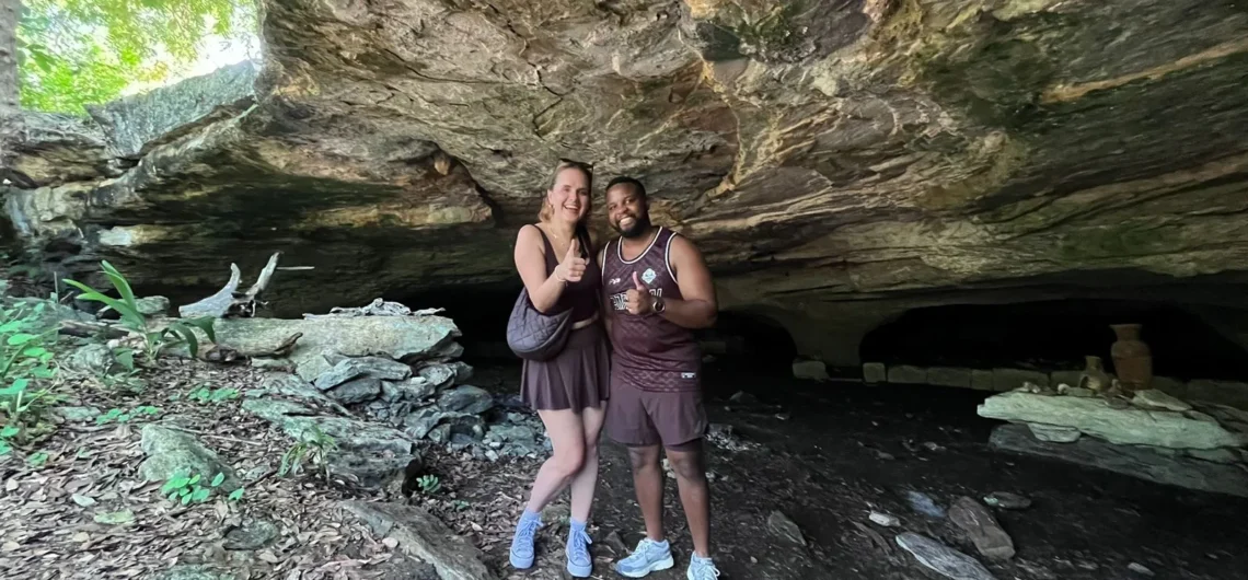 Happy couple giving thumbs up while exploring a hidden Mayan cave during a private adventure tour in Cozumel.